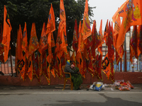 A woman with a child is selling Lord Ram and Sita devotional flags at a roadside shop ahead of the Ram temple opening in Ayodhya, Uttar Prad...