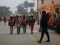 Construction workers are walking near the Ram Temple construction site ahead of the temple's opening in Ayodhya, Uttar Pradesh, India, on Ja...