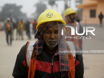 A construction worker is walking near the Ram Temple construction site ahead of the temple's opening in Ayodhya, Uttar Pradesh, India, on Ja...