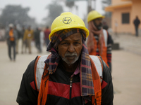 A construction worker is walking near the Ram Temple construction site ahead of the temple's opening in Ayodhya, Uttar Pradesh, India, on Ja...