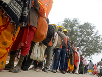 People are standing in a queue for free food near a temple area ahead of the Ram temple opening in Ayodhya, India, on January 20, 2024. (