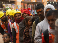People are standing in a queue for free food near a temple area ahead of the Ram temple opening in Ayodhya, Uttar Pradesh, India, on January...