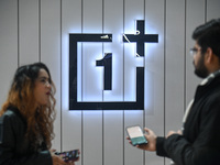 Media personnel are standing near a OnePlus logo during the launch event of two new smartphones, the OnePlus 12 and OnePlus 12R, in New Delh...