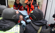 First responders are putting an injured senior man into an ambulance after the Russian mis...