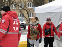 Volunteers from a rapid response unit of the Ukrainian Red Cross Society are setting up a tent to provide help for people being evacuated fr...