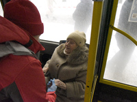 In Kyiv, Ukraine, on January 23, 2024, a senior woman is receiving help to board a bus as she waits for permission to return to her five-sto...