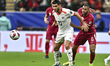 Islam Batran (L) of Palestine is battling for the ball with Boualem Khoukhi of Qatar durin...