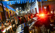 A police car is being surrounded by revelers during a pre-carnival street party in Olinda,...