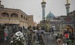 Members of the Iranian police special forces are walking alongside a street near a holy sh...