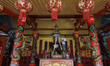 A worker is installing Chinese decorations and repainting the ornaments as part of the pre...