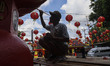 People are installing Chinese decorations and repainting the ornaments as part of the prep...