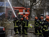 Firefighters are working at the site of a burning residential high-rise building that was damaged by a massive Russian missile strike in Kyi...