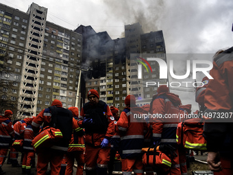 Rescuers are working at the site of a burning residential high-rise building that was damaged by a massive Russian missile strike in Kyiv, U...