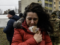 A local woman with a cat is reacting next to a burning residential high-rise building damaged by a massive Russian missile strike in Kyiv, U...