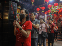 A person of Chinese descent is performing a prayer during the Chinese New Year Eve celebration at Hong San Ko Tee Temple in Surabaya, East J...