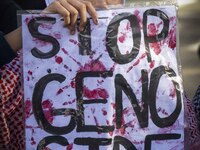 A person is holding a banner with the inscription ''Stop the genocide'' during a demonstration in central Lisbon, Portugal, on February 10,...