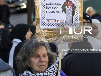An activist is holding up posters with pro-Palestinian inscriptions during a rally for Palestine in downtown Lisbon, Portugal, on February 1...