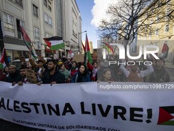 People are carrying Palestinian flags and banners with anti-Israel slogans, and they are shouting slogans as they march during a demonstrati...