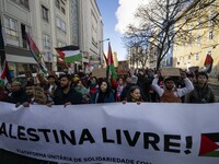 People are carrying Palestinian flags and banners with anti-Israel slogans, and they are shouting slogans as they march during a demonstrati...