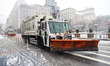A New York City sanitation vehicle is spreading salt across E. 14th Street after a winter...