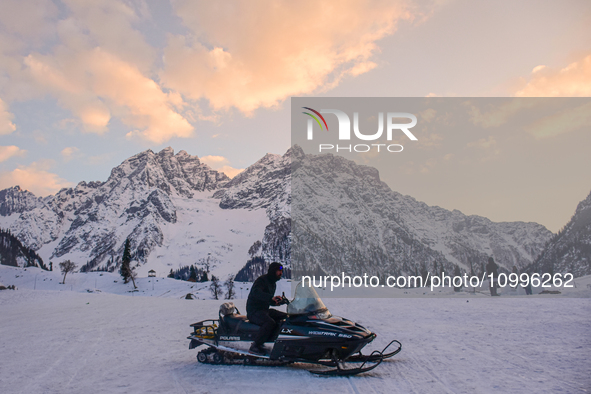 A man is riding a snow scooter on a sunny winter day in Sonmarg, a tourist destination in the Ganderbal district of Jammu and Kashmir, on Fe...