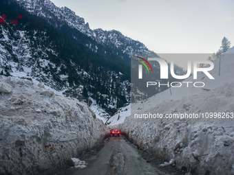 Vehicles are passing through a snow tunnel on a sunny winter day in Sonmarg, a tourist destination in the Ganderbal district of Jammu and Ka...