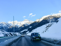 Vehicles are plying through the snow-covered mountains on a sunny winter day in Sonmarg, a tourist destination in the Ganderbal district of...