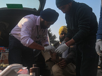 Medical staff are bandaging a farmer's toe because he was injured while the farmers are marching towards New Delhi to demand the Minimum Sup...