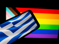 The flag of Greece is being displayed on a smartphone screen, and an LGBTQ flag is being shown on a MacBook screen in Athens, Greece, on Feb...