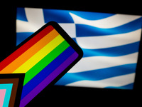 The LGBTQ flag is being displayed on a smartphone screen and the flag of Greece is being shown on a MacBook screen in Athens, Greece, on Feb...