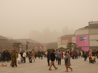 Tourists are wearing masks as they visit the Dayan Pagoda scenic spot during a dusty day in Xi'an, China, on February 18, 2024. It is unders...