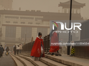 Pedestrians are walking on a street during dusty weather in Xi'an, Shaanxi Province, China, on February 18, 2024. It is understood that at 6...