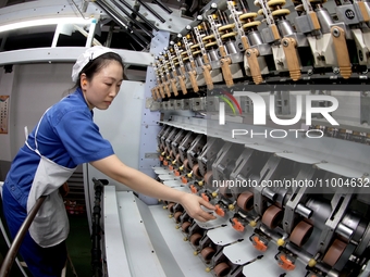 A worker is inspecting production at a workshop of a chemical fiber company in Suqian, East China's Jiangsu province, on February 18, 2024....