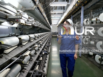 A worker is inspecting production at a workshop of a chemical fiber company in Suqian, East China's Jiangsu province, on February 18, 2024....