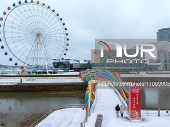 Tourists are visiting the Rainbow Bridge after snowfall in the West Coast New Area of Qingdao, Shandong Province, China, on February 20, 202...