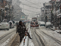 People are walking amid snowfall in Baramulla, Jammu and Kashmir, India, on February 20, 2024. (