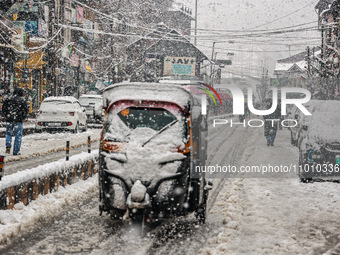People are walking amid snowfall in Baramulla, Jammu and Kashmir, India, on February 20, 2024. (