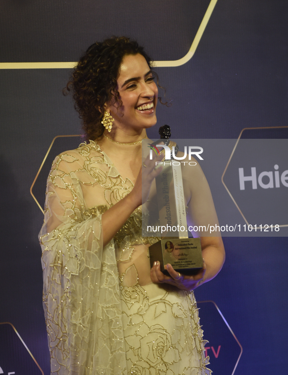 Bollywood actress Sanya Malhotra is posing for a photoshoot while holding an award in her hand during a red carpet event of the 'Dadasaheb P...