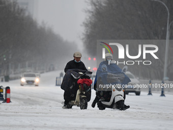 Citizens are riding in the snow on a street in Fuyang, China, on February 21, 2024. (