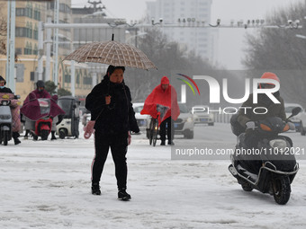 Citizens are walking in the snow on a street in Fuyang, China, on February 21, 2024. (