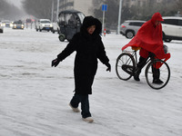 Citizens are walking in the snow on a street in Fuyang, China, on February 21, 2024. (