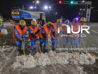 Sanitation workers are removing snow from a main road in Suqian, Jiangsu Province, China, on February 21, 2024. (