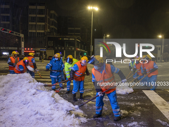 Sanitation workers are removing snow from a main road in Suqian, Jiangsu Province, China, on February 21, 2024. (