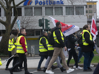 Employees from Postbank branches are marching past a Postbank branch during the strike in Essen, Germany, on February 21, 2024, as the Verdi...
