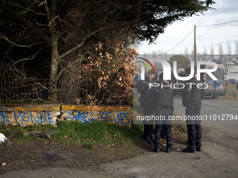 Gendarmes Mobiles are standing guard near the 'Crem'Arbre' ZAD in Saix, Tarn, France, on February 21, 2024. The graffiti reads 'A world with...