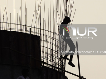 A construction worker gets off from an elevated water tank after work in Ajmer, India, on 22 February 2024. (