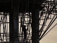 A construction worker gets off from an elevated water tank after work in Ajmer, India, on 22 February 2024. (