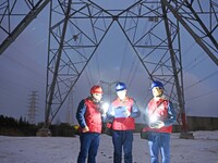 Electric workers are braving cold temperatures in the snow to inspect the 500-kilovolt cross-city transmission line and the Beijing-Shanghai...
