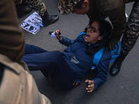 An activist is reacting as police personnel detain her during a protest against the killings of farmers in clashes with the police at the bo...