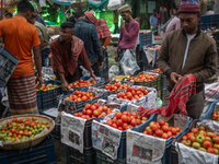 Vendors are preparing tomatoes for sale at the Kawran Bazar wholesale market in Dhaka, Bangladesh, on February 23, 2024. (